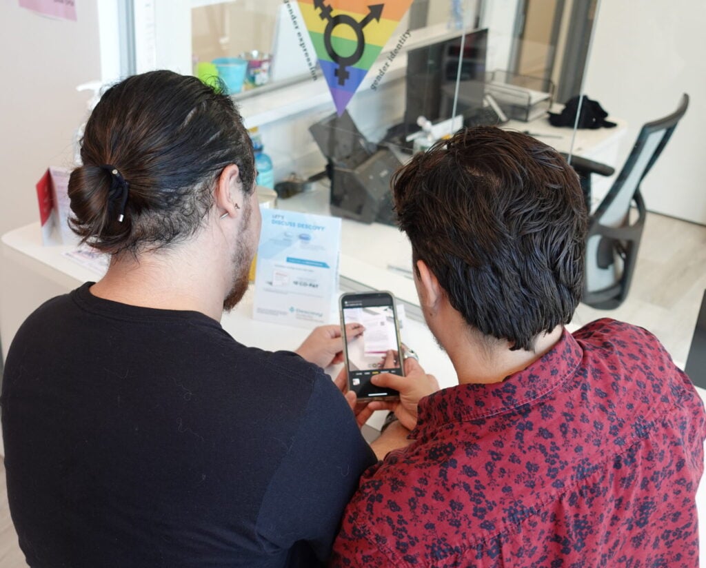 Two patients in our waiting room taking a picture of a flyer.