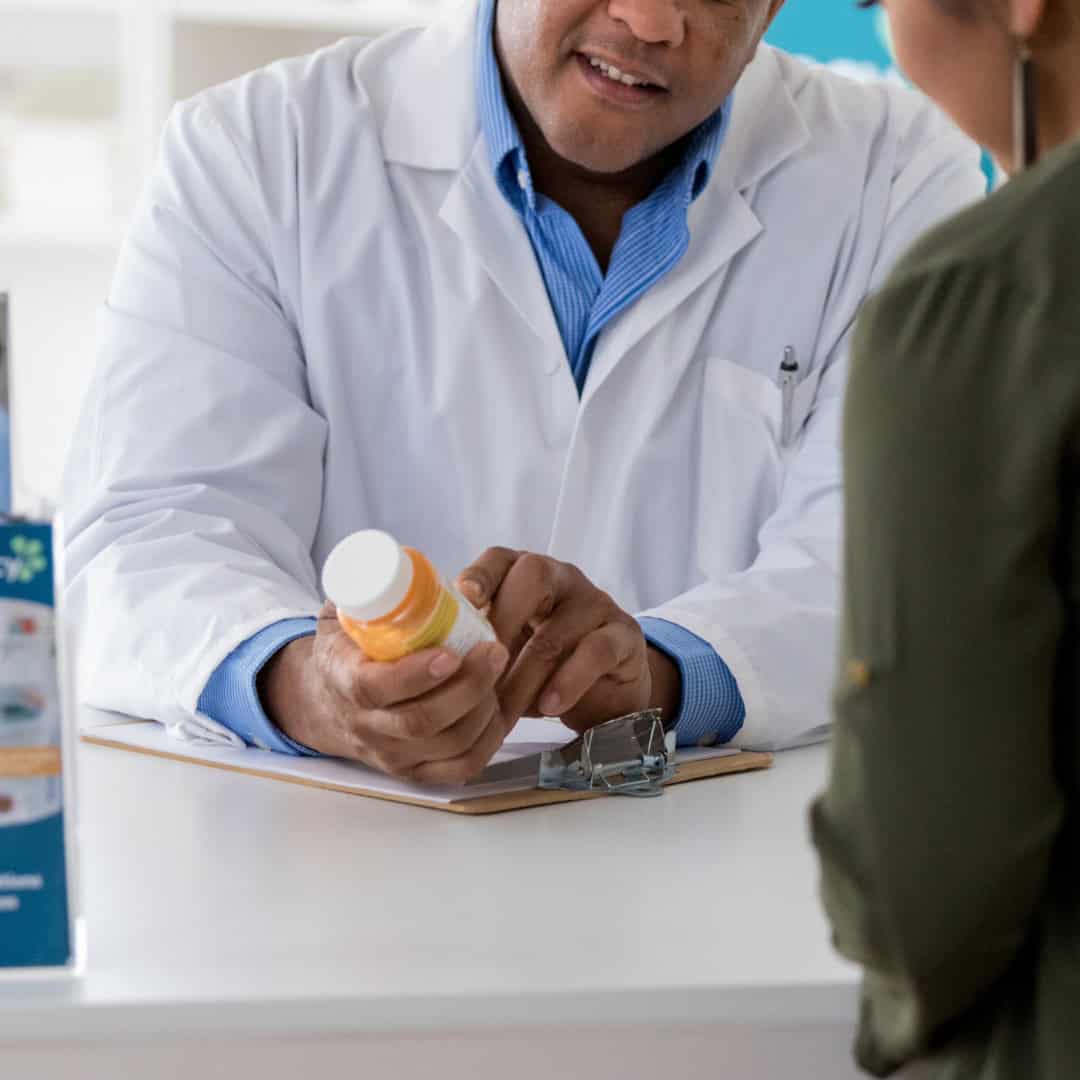 A pharmacist reviewing a prescription with a patient.